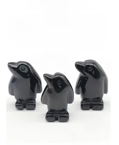 Detailed trio of obsidian penguin carvings in varied sizes with natural polished finish