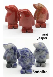 Detail of hand-carved penguin ornaments in natural red jasper and blue sodalite stone