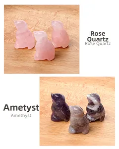 Detail of hand-carved rose quartz and amethyst bird figurines on wooden background