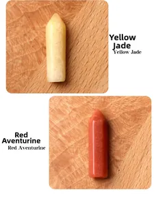 Macro detail of Yellow Jade and Red Aventurine hexagonal crystal towers on wood