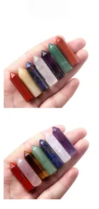 Macro shot of natural seven chakra hexagonal crystal points held in hand showing smooth polish
