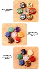 Three sets of polished 7 Chakra healing stones with Reiki symbols on light wood background
