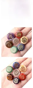Detailed view of hand-held chakra stones with gold engraved reiki symbols on polished crystals