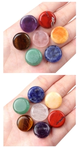 Macro shot of seven polished natural chakra stones with smooth textures held in hand
