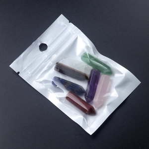 Set of seven assorted natural chakra crystal hexagonal pillars in clear plastic packaging
