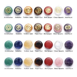 Set of seven natural chakra stones with gold engraved reiki symbols in grid layout