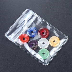 Set of 7 natural chakra healing crystals in doughnut shape on black background