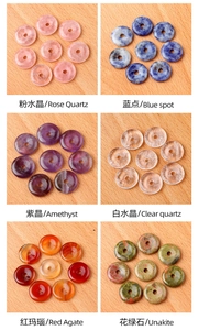 Macro display of mixed natural gemstone donut pendants and polished healing crystal charms