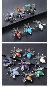 Detail view of vintage bee brooches with antique silver alloy wings and colorful stones