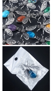 Detailed macro view of bee brooches with colorful stones and silver metal finish