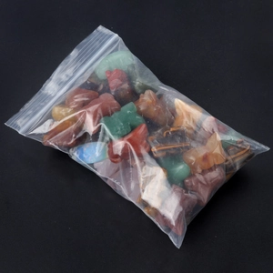 Carved natural crystal animal figurines including lizard and elephant in bulk packaging