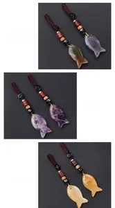 Detailed close-up of handmade fish pendants carved from Indian Agate and Amethyst