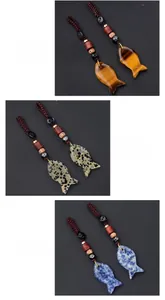 Detailed view of hand-woven fish pendants in Tiger Eye, Dalmatian, and Blue Spot stones