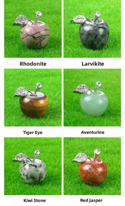 Macro display of assorted 25mm crystal apple figurines with silver leaf on green turf