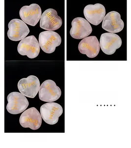 Detail of pink quartz heart stone with golden engraved words Belief Strength and Trust