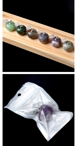 Detailed view of apple crystal stone ornaments with sparkling metal leaves in clear packaging