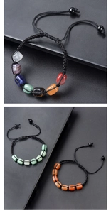 Detalle de pulsera de piedras chakra ajustable con cuentas de colores y cordón negro