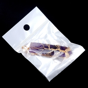 Amethist hanger in zwaardvorm met gouden levensboomdraad in een winkelverpakking
