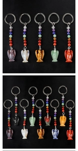 Détails de porte-clés ange sculptés en pierres naturelles de chakra sur un fond noir texturé
