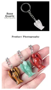 Detail of hand holding crystal angel keychains in rose quartz and tiger eye stones