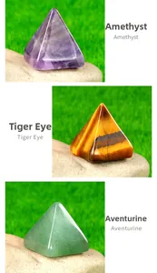 Close-up of Amethyst, Tiger Eye and Aventurine stone pyramids on natural raw stone