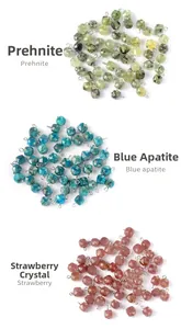Macro detail of 9mm faceted crystal beads in prehnite blue apatite and strawberry quartz