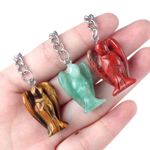 Three hand-held natural stone angel pendants in tiger eye, aventurine and red jasper