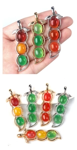 Detailed view of tri-color agate bean pendants in green, red, and yellow with metal leaves