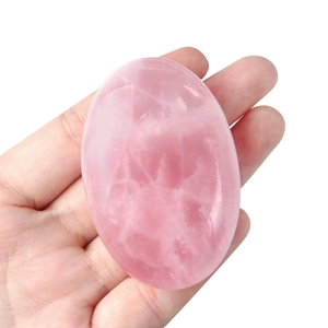 Handheld natural rose quartz stone in smooth oval shape for yoga and meditation