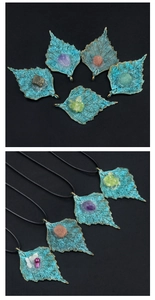 Detailed macro view of vintage bronze maple leaf pendants with assorted natural gemstones