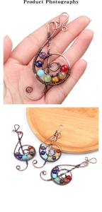 Macro shot of treble clef spiral pendant with seven chakra stones in antique bronze wire