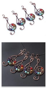 Macro view of copper wire-wrapped treble clef pendant with seven chakra stones