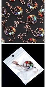 Detailed macro view of handmade copper wire music note pendant with seven chakra stones