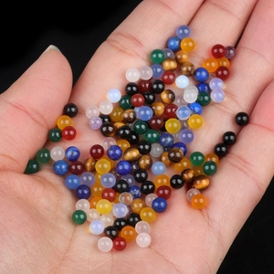 Mix of 4mm colorful natural crystal stone round beads held in palm for scale
