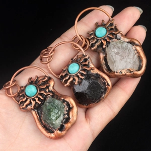 Handheld vintage bronze sunburst pendants with natural raw crystals and turquoise stones