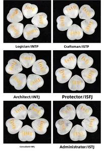 Macro view of heart-shaped white crystal stones engraved with golden MBTI personality types