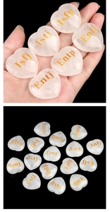Macro shot of rose quartz heart stone with golden engraved MBTI personality type text