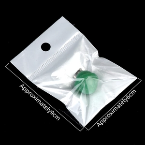 Green crystal planet pendant with metal bail in clear packaging on black background