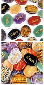 Détail de pierres naturelles assorties avec des mots de motivation gravés en doré