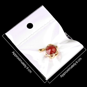 Red agate star pendant in gold cage frame inside transparent packaging with size info