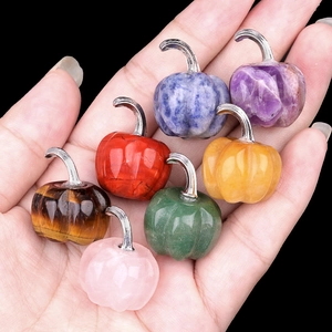 Mini gemstone pumpkins made of natural amethyst and tiger eye held in hand for decoration