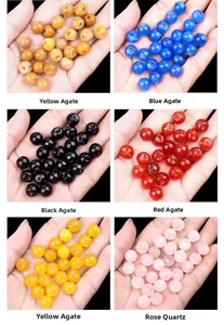 Macro detail of various colorful gemstone beads held in palm to show size and texture