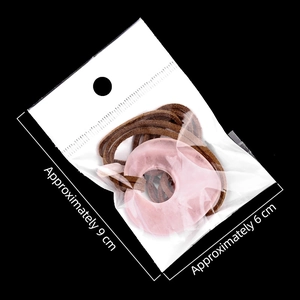 Roze kristallen hanger met bruin koord in een verpakking van 9x6 cm groot
