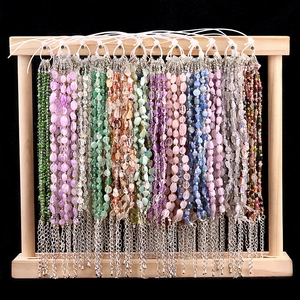 Handmade natural tumbled stone bracelets with adjustable metal chains on wooden display stand