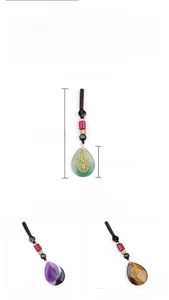 Detailed view of teardrop Hamsa Hand crystal pendants with amethyst and tiger eye textures