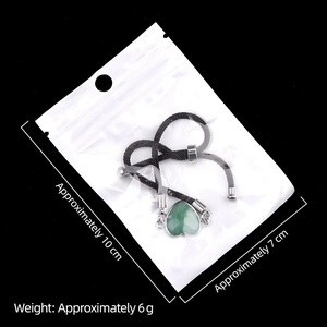 Verstellbares Armband mit grünem Herz-Naturstein und schwarzer Kordel in 10x7cm Packung