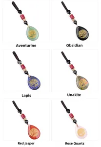 Macro display of teardrop natural stones with golden Tree of Life symbol engravings