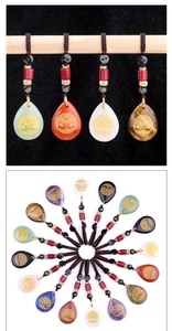 Detailed view of water-drop gemstone pendants with engraved gold Tree of Life symbols