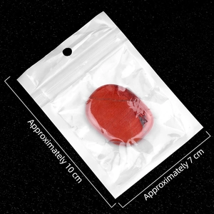 Polished red jasper oval worry stone with dark natural veins in a clear storage bag