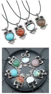 Detailed view of various vintage owl pendants with inlaid colorful gemstones and crystals